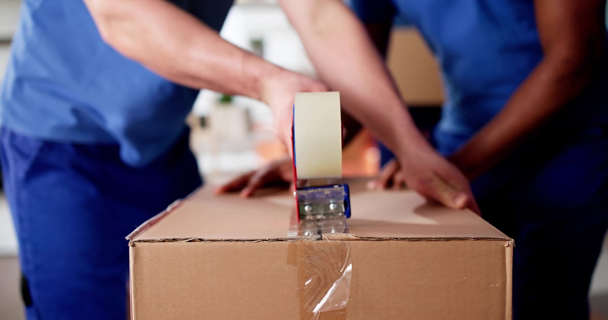 Professionelle Umzugshelfer beim Verpacken von Umzugskartons