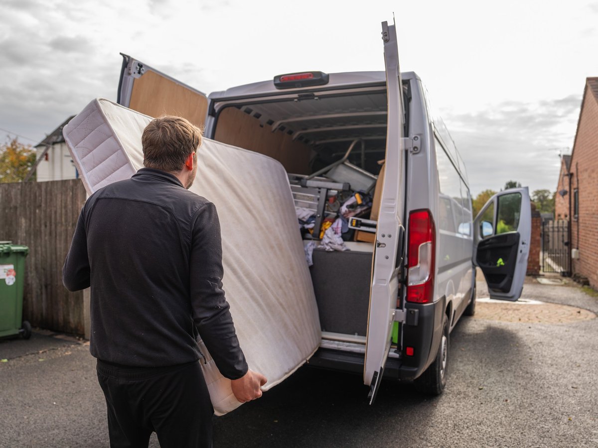 Umzugshelfer trägt eine Matratze in den Transporter – Möbeltransport von Movatrans