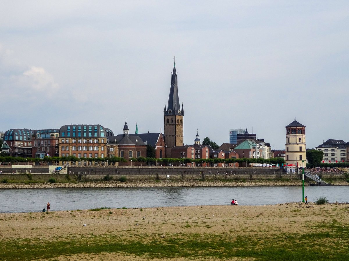 Düsseldorfer Rheinufer mit historischer Stadtsilhouette, Kirchturm, Schlossturm und Sandstrand am Rheinufer